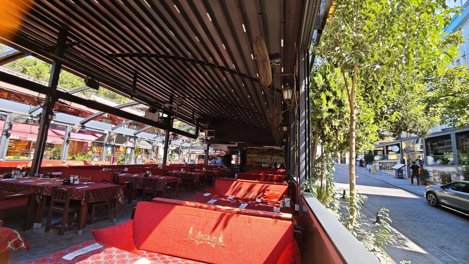 Le jardin de Meşale, toit rétractable, tables dressées et divans rouges