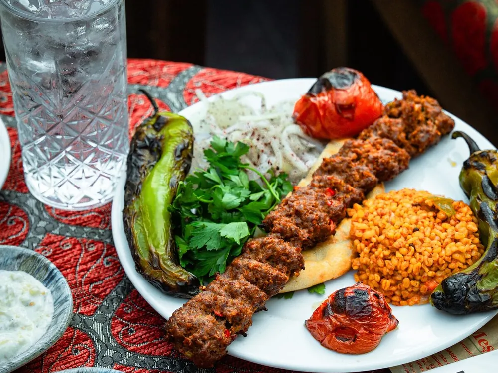 Kebab grillé au charbon avec pilaf de boulgour et poivrons grillés